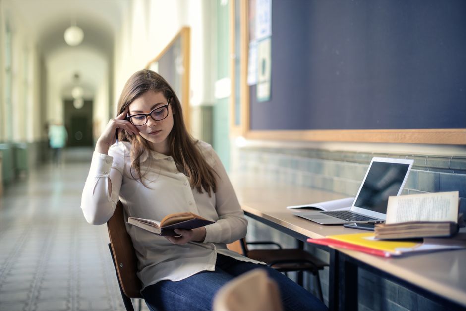 Studentica uči u hodniku sveučilišta s knjigom