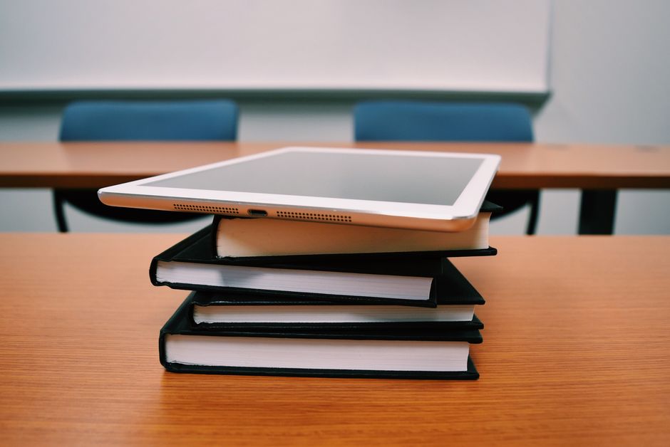 Tablet na hrpi knjiga u praznoj učionici