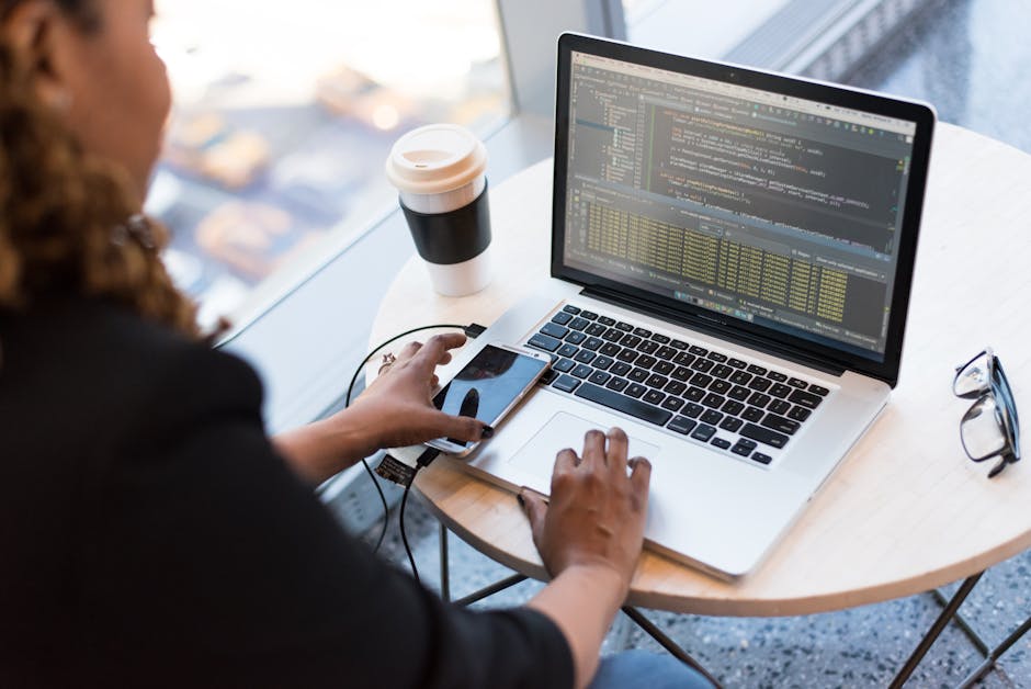 Woman programming on a laptop with coffee